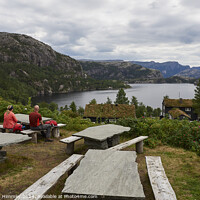 Buy canvas prints of A couple relaxes at Preikestolen Base Camp with a view of Lake R by Andreas Himmler