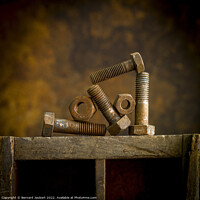 Buy canvas prints of Rusty bolt on a wooden surafce by Bernard Jaubert