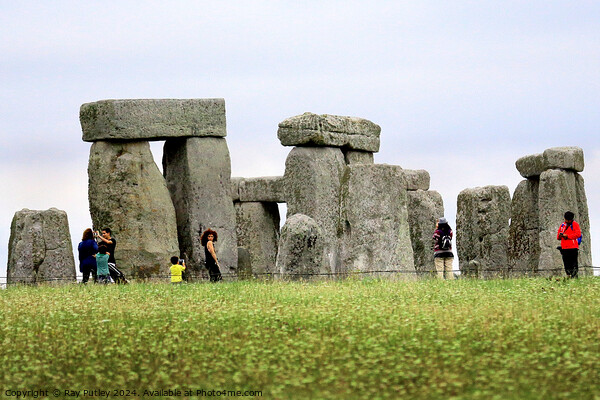 A group of people that are standing in the grass with Stonehenge in the background Picture Board by Ray Putley