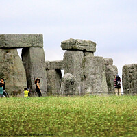 Buy canvas prints of A group of people that are standing in the grass with Stonehenge in the background by Ray Putley