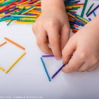 Buy canvas prints of Kid making geometric shapes with colorful sticks o by Turgay Koca