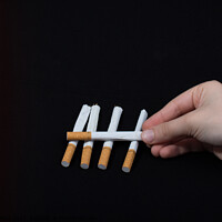 Buy canvas prints of Hand is holding crossed cigarettes on black background by Turgay Koca