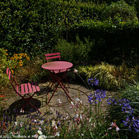 Buy canvas prints of Floral Garden with a Rustic Iron Table and Chairs. by Steve Gill
