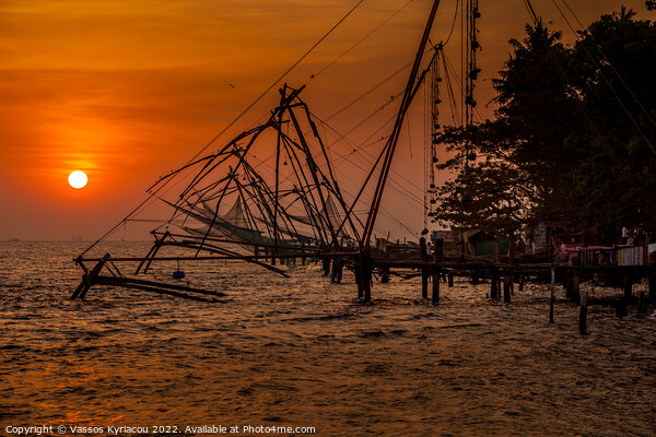 Red Sunset over Cochin Fishing Nets in India Picture Board by Vassos Kyriacou
