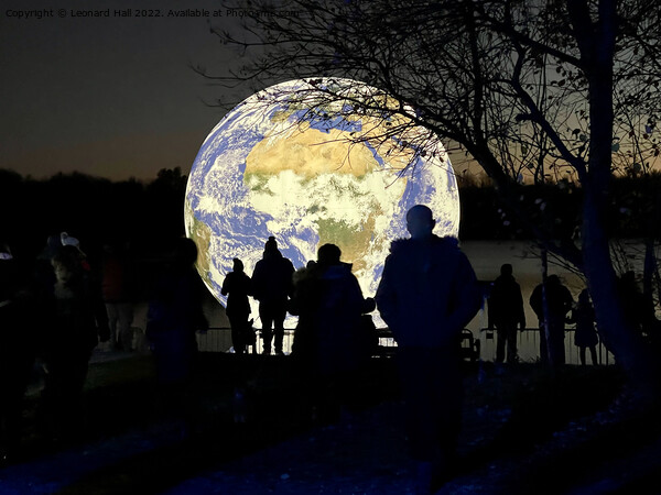 People silhouetted on an Earth artwork on Penningt Picture Board by Leonard Hall