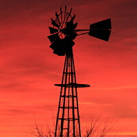 Buy canvas prints of Kansas Sunset with a red Sky and Windmill silhouet by Robert Brozek