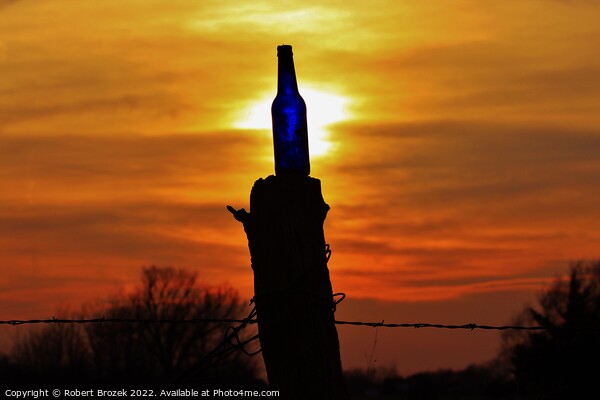 Sunset with a bottle on a fence post with sky. Picture Board by Robert Brozek