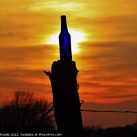 Buy canvas prints of Sunset with a bottle on a fence post with sky. by Robert Brozek