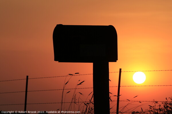 Mailbox silhouette at sunset with orange sky Picture Board by Robert Brozek