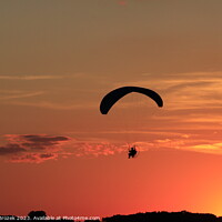 Buy canvas prints of Paraglider at Sunset with a colorful sky. by Robert Brozek
