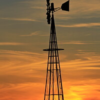 Buy canvas prints of Kansas Golden Sky with clouds with a Farm Windmill silhouette by Robert Brozek
