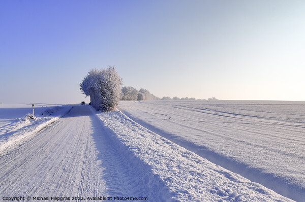 View of a snow-covered country road in winter with sunshine and  Picture Board by Michael Piepgras