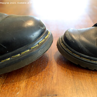 Buy canvas prints of Big and small old black leather shoe on a wooden floor by Michael Piepgras