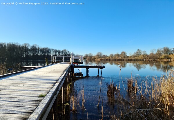 Beautiful landscape on a jetty by a lake with blue sky. Picture Board by Michael Piepgras