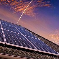 Buy canvas prints of Solar panels producing clean energy on a roof of a residential house during sunset. by Michael Piepgras