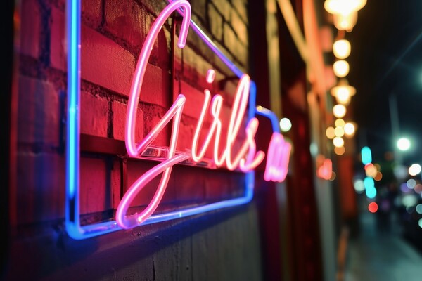 A colorful neon sign showing the word Girls on the wall of a clu Picture Board by Michael Piepgras