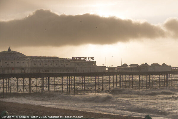 Brighton Pier on a stormy windy day with sun coming through clouds Picture Board by Samuel Foster
