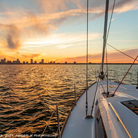 Buy canvas prints of Yacht sailing towards cityscape on horizon at sunset by Spotmatik 