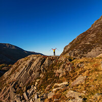 Buy canvas prints of Happy female backpacker on rugged mountain peak Snowdonia by Spotmatik 