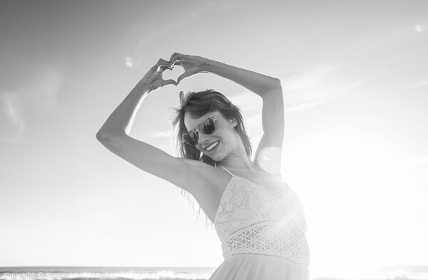 Bohemian girl showing heart sign dancing on beach Picture Board by Spotmatik 