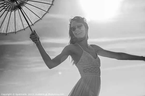 Young American female dancing on beach with parasol Picture Board by Spotmatik 