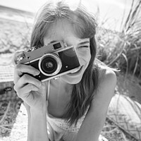 Buy canvas prints of Smiling Caucasian girl with retro camera photograph beach vacation by Spotmatik 
