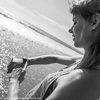 Buy canvas prints of Caucasian female on ocean edge checking sports watch by Spotmatik 