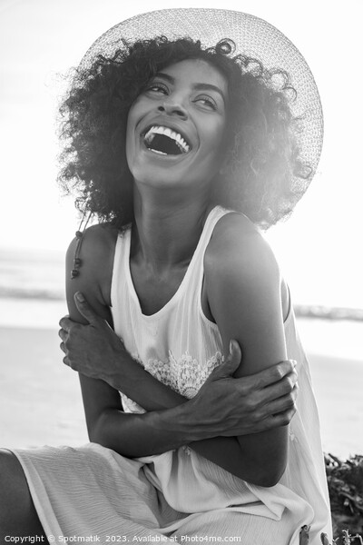 Laughing Afro American female wearing hat on beach Picture Board by Spotmatik 