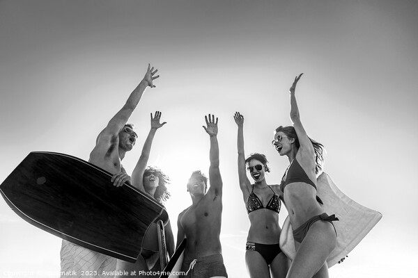 Friends in swimwear carrying bodyboards celebrating fun activity Picture Board by Spotmatik 