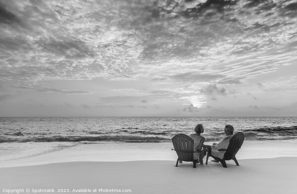 Retired couple enjoying tropical sunrise over ocean Bahamas Picture Board by Spotmatik 