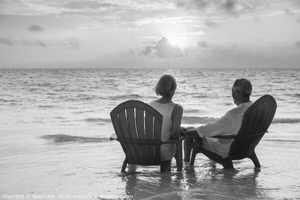 Retired couple enjoying sunset view over ocean Bahamas Picture Board by Spotmatik 