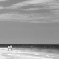 Buy canvas prints of Mature couple walking along shoreline at beach resort by Spotmatik 