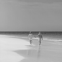 Buy canvas prints of Retired couple holding hands enjoying walk on beach by Spotmatik 