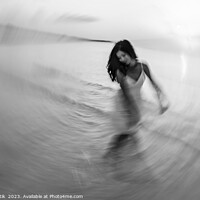 Buy canvas prints of Motion blurred dancing Asian girl in ocean sunset by Spotmatik 