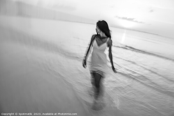 Motion blurred woman walking through waves at sunset Picture Board by Spotmatik 