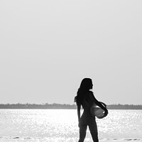 Buy canvas prints of Tropical ocean sunrise with girl holding beach ball by Spotmatik 