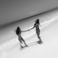 Buy canvas prints of Motion blurred women in swimwear playing by ocean by Spotmatik 