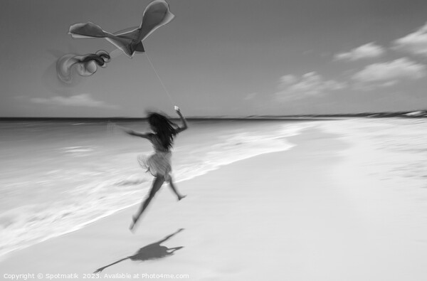 Motion blurred woman jumping on beach flying kite Picture Board by Spotmatik 