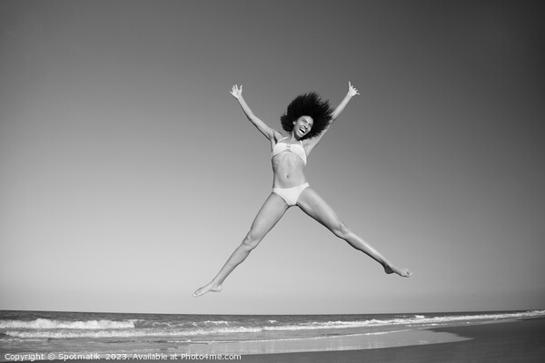 Happy African American girl jumping by the ocean Picture Board by Spotmatik 