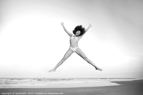 Healthy African American girl jumping high on beach Picture Board by Spotmatik 