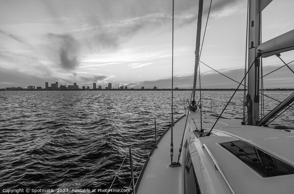 Yacht sailing towards cityscape on horizon at sunset Picture Board by Spotmatik 