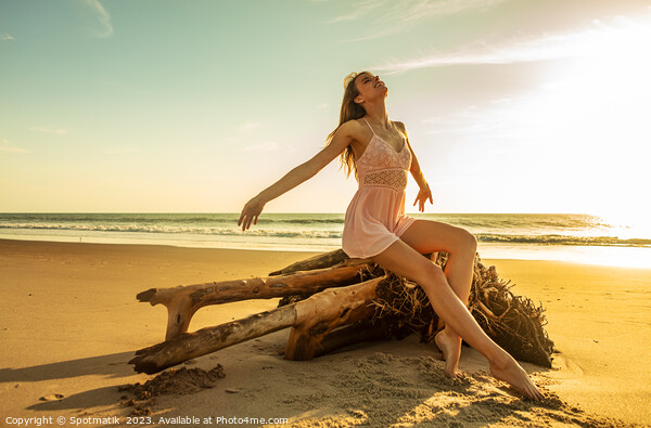 Young Caucasian girl enjoying sun sitting on driftwood  Picture Board by Spotmatik 