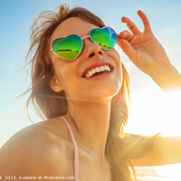Buy canvas prints of Caucasian girl wearing heart shaped sunglasses on beach by Spotmatik 