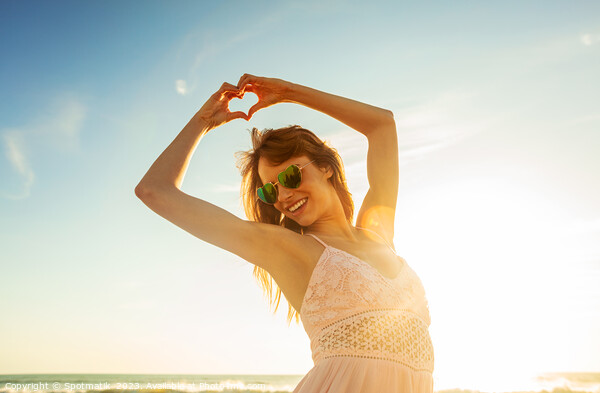 Bohemian girl showing heart sign dancing on beach Picture Board by Spotmatik 
