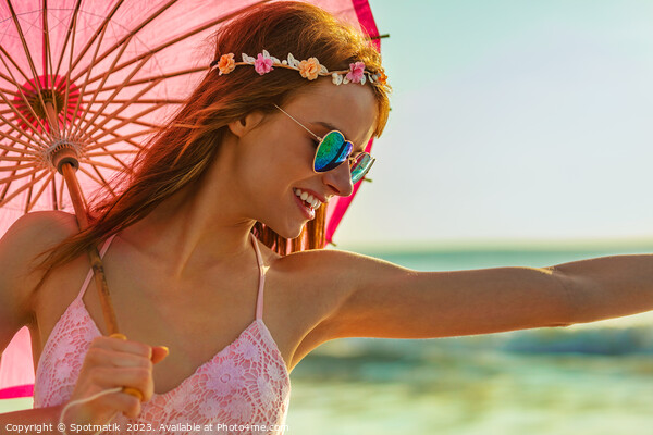 Hippy chic in sunglasses by ocean with parasol Picture Board by Spotmatik 