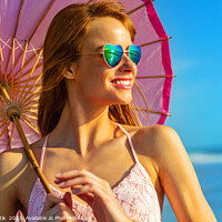 Buy canvas prints of Smiling American hippy chic with parasol on beach by Spotmatik 