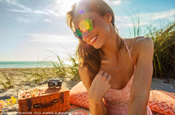 Smiling Caucasian girl relaxing on blanket at beach Picture Board by Spotmatik 