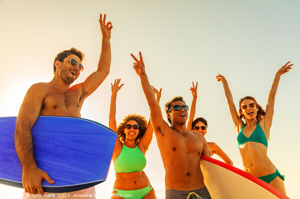 Friends enjoying carefree fun going bodyboarding on beach Picture Board by Spotmatik 