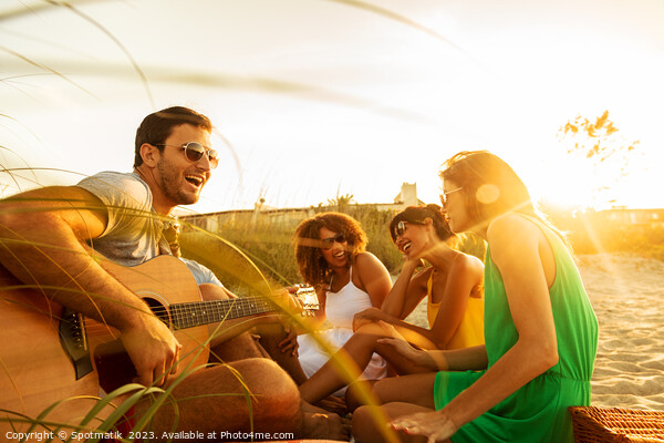 Young friends enjoying guitar music on beach vacation Picture Board by Spotmatik 