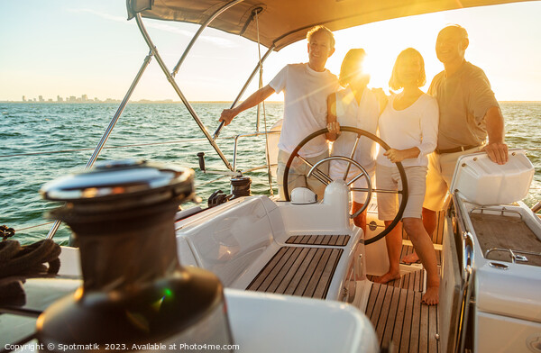 Senior friends enjoying retirement steering yacht at sunset Picture Board by Spotmatik 